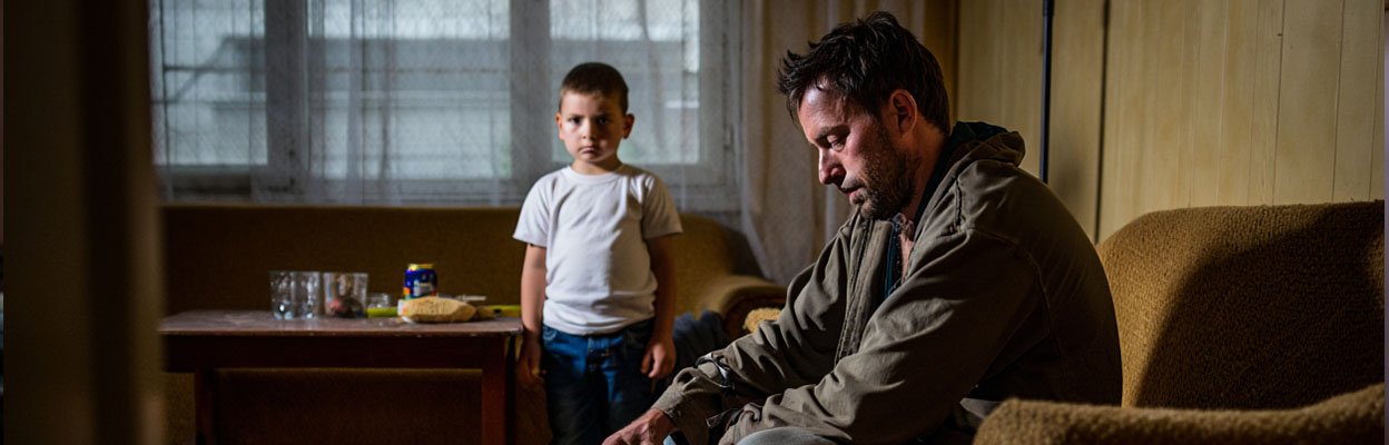 Мужчина пьет пиво, а его сын наблюдает